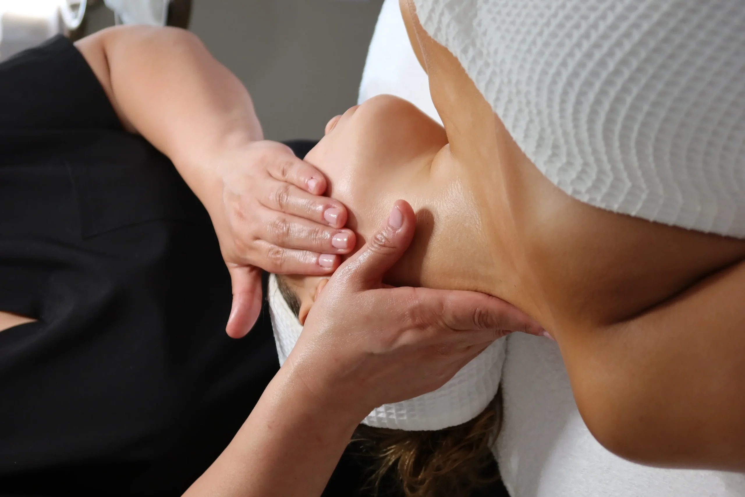Professional performing facial treatment on woman at evolve spa